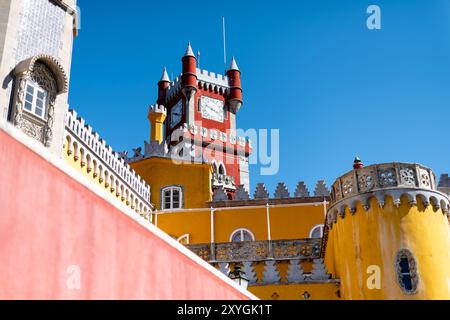 SINTRA, Portugal — The ornate red turret clock tower of Pena Palace stands out against the sky, showcasing the vibrant colors and eclectic Romanticist architecture of this 19th-century royal residence. This distinctive feature epitomizes the fairytale-like charm that makes Pena Palace a must-see landmark in Sintra. Stock Photo