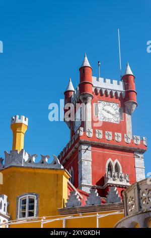 SINTRA, Portugal — The ornate red turret clock tower of Pena Palace stands out against the sky, showcasing the vibrant colors and eclectic Romanticist architecture of this 19th-century royal residence. This distinctive feature epitomizes the fairytale-like charm that makes Pena Palace a must-see landmark in Sintra. Stock Photo