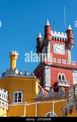 SINTRA, Portugal — The ornate red turret clock tower of Pena Palace stands out against the sky, showcasing the vibrant colors and eclectic Romanticist architecture of this 19th-century royal residence. This distinctive feature epitomizes the fairytale-like charm that makes Pena Palace a must-see landmark in Sintra. Stock Photo