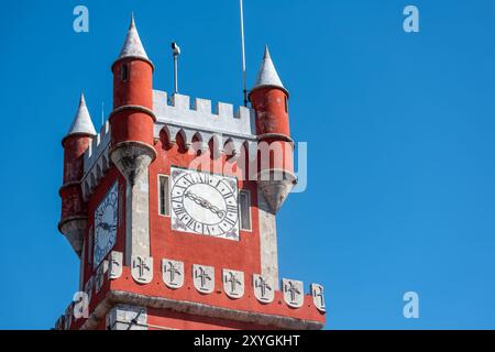 SINTRA, Portugal — The ornate red turret clock tower of Pena Palace stands out against the sky, showcasing the vibrant colors and eclectic Romanticist architecture of this 19th-century royal residence. This distinctive feature epitomizes the fairytale-like charm that makes Pena Palace a must-see landmark in Sintra. Stock Photo