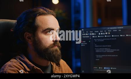 Developer overthinking solutions while doing programming during remote job shift in office while drinking coffee. IT admin enjoying hot beverage working on PC early in the morning, camera A close up Stock Photo
