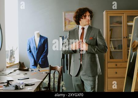 Brutal male model adjusting jacket while looking in mirror Stock Photo