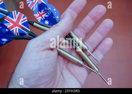 with darts in one hand to play a game Stock Photo