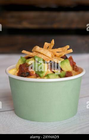 Breakfast chilaquiles in a paper cup with eggs, salsa, avocado, and tortilla strips Stock Photo
