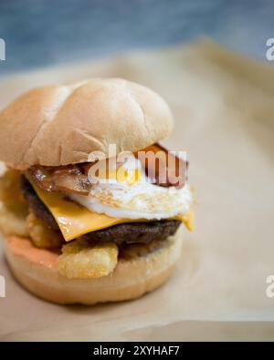 Hot breakfast slider sandwich with egg, bacon, sausage, cheese, and tater tots Stock Photo