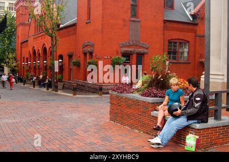 A young couple sits outside the historic Central Market in Lancaster, Pennsylvania Stock Photo