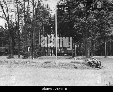 US troops in action during the final assault on Dachau. Dachau was the first nazi concentration camp, opening on 22 March 1933 (just 7 weeks after Hitler came to power). Although it was a forced labour camp and there were no gas chambers there, brutality and violent punishments were the norm. There were 32000 documented deaths there and many thousands more undocumented. The main camp (Dachau had 100 sub-camps) was liberated by the US Army on 29th April 1945. Stock Photo