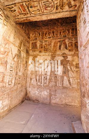 Painted Wall carving of the pharaoh Ramesses III making an offering to the god Amun-Ra in the Mortuary Temple of Medinet Habu inside the Royal treasure room at Luxor,Egypt Stock Photo