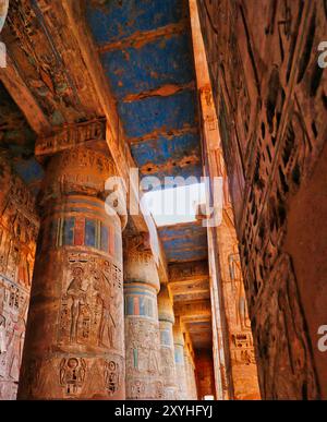 Magnificent bright colors on the pillars and inscriptions inside the magnificent Temple of Medinet Habu - Mortuary Temple of Ramesses III built around 1170 BC at Luxor,Egypt Stock Photo