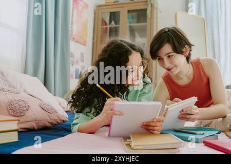 Friends Studying Together in Cozy Bedroom Setting Stock Photo