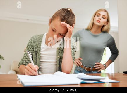 Girl, homework and frustrated mother in home for project deadline, learning discipline and headache of pressure. Education, woman and daughter with Stock Photo