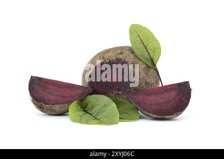 Slices of beetroot showing their purple interior arranged next to whole beetroots vegetables with their green leaves still attached isolated on white Stock Photo