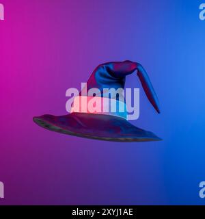 Witch hat floating on a gradient purple and blue background, creating a spooky and festive atmosphere. 3d rendering Stock Photo
