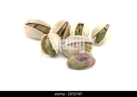 Pistachios in-shell and others peeled exposing the green nuts inside isolated on white background Stock Photo