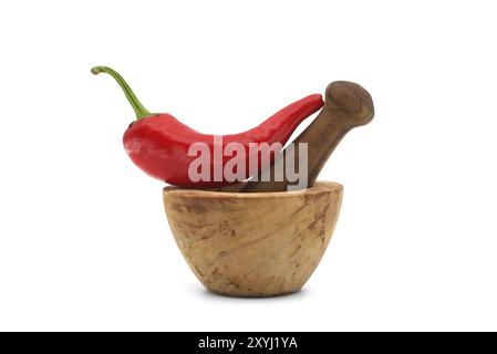 Fresh red chili pepper and old rustic wooden pestle with mortar isolated on a white background Stock Photo