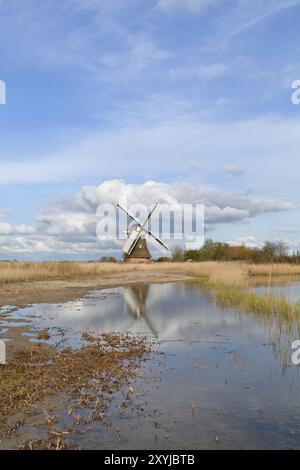 Dutch windmill over blue sky and river, Holland Stock Photo