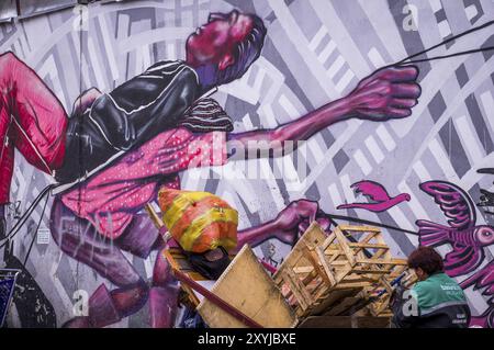 Bogota, Colombia on December 14, 2015: Wall covered in anti-capitalistic street art by artist Guache in La Candelaria neighborhood of Bogota showing a Stock Photo