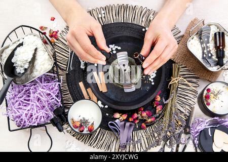 Handmade aroma candle with roses. DIY. Hobby process on light wooden background. Top view Stock Photo