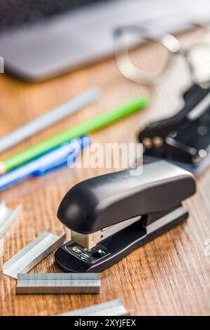 Black office stapler on a wooden table. Stock Photo