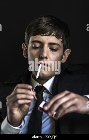 Young man in a suit smoking a cigarette Stock Photo