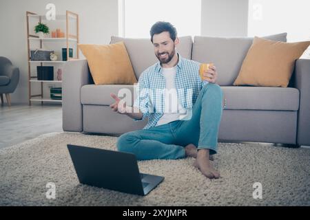 Photo of handsome businessman mature age man staying home working remote control all processes when drinking tea using laptop Stock Photo