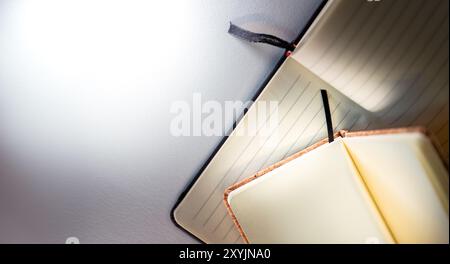 Two open notebooks. Lined and clean pages. Cork binding. White background copy space. Stock Photo