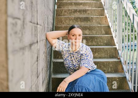 Fashion portrain of pretty 40 - 45 year old woman posing outdoors Stock Photo