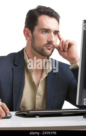 Man looking at a computer screen, thinking about the job at hand Stock Photo