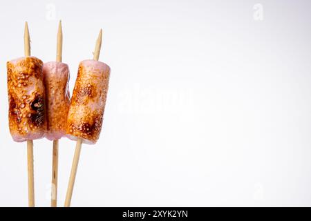 Detailed image of toasted marshmallows on skewers, showing the perfect caramelization. Positioned on the left side of the horizontal photo with a plai Stock Photo