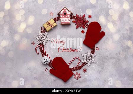 Christmas or new year background with red festive ornaments and text Merry Christmas in a circle, flat lay overhead view Stock Photo