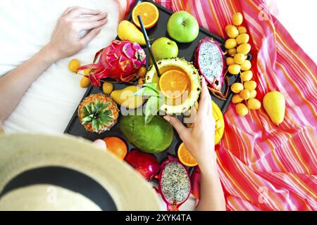 Young woman and exotic fruits on the tray Close up Stock Photo