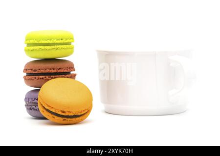 Tower of sweet macarons and a cup of hot tea on white background Stock Photo