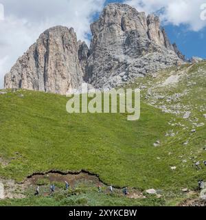 landscape with hikers on path on Sasso Lungo southern slope, shot in bright summer light near Col Rodella, Italy Stock Photo