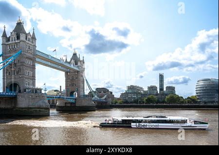 An Uber Boat passenger ferry passing Tower Bridge in summer, London Stock Photo