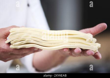 Pastry chef showing dough sheets ready to be rolled to produce croissant Stock Photo