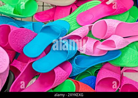 women's multi-colored flip-flops in a container in a supermarket Stock Photo