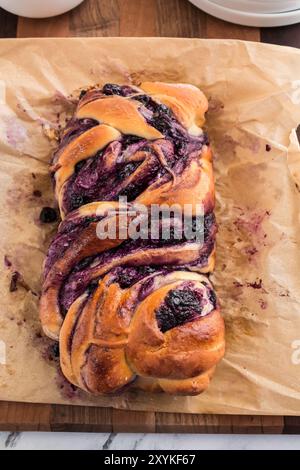 Whole blueberry cream cheese babka on parchment paper, freshly baked Stock Photo