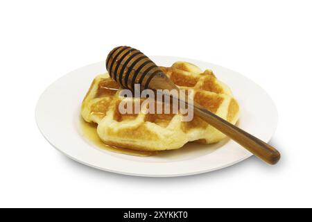 Waffle with honey in a plate on white background Stock Photo