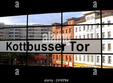 Kottbusser tor lettering in the underground station, in front of high-rise blocks of flats from the 70s and typical old berlin houses Stock Photo