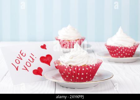 Cupcakes with white buttercream frosting on white wooden table Stock Photo
