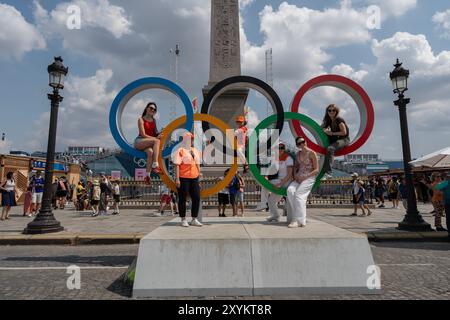 Specators pose for a photograph inside the olympic rings in Place de la Concorde during the 2024 Olympic Games, on Friday, August 2, 2024, in Paris, F Stock Photo