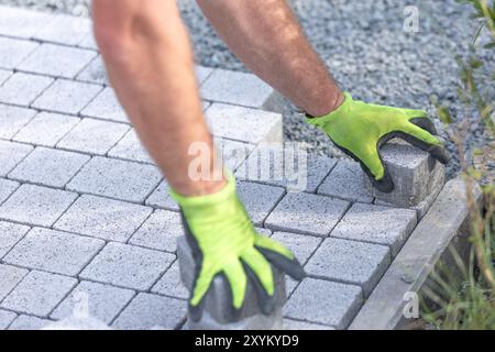 Worker building a new interlocking pavement from concrete paving, a new path building concept Stock Photo