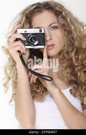 Portrait of the beautiful blond girl in white with old camera Stock Photo