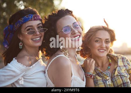 Happy slim tan women are dancing on the beach in sunset. Travel and happiness concept Stock Photo