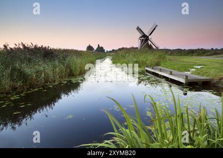 Sunrise over river and Dutch windmill, Groningen, Netherlands Stock Photo