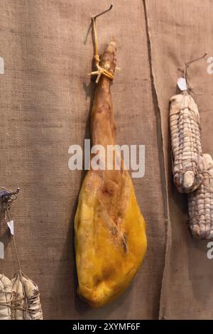 A leg of Spanish ham. Hamon iberico in the background in retro style. Food Stock Photo