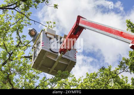 Man in protective working clothes looking down from aerial platform Stock Photo