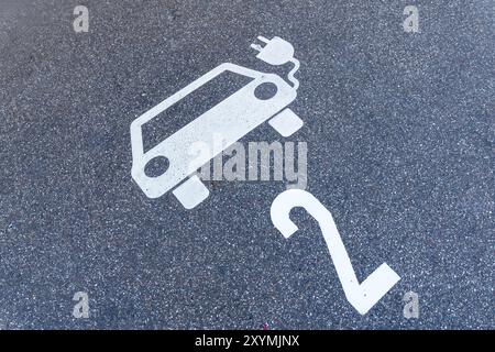 parking lot for electric cars, pictogram of a car with a plug and number 2 on the floor Stock Photo