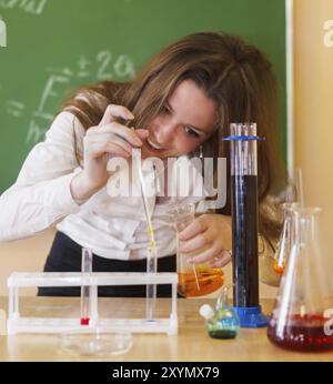Girl working in chemistry laboratory with liquid formula at the classroom Stock Photo