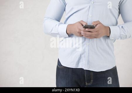 Young man using a smartphone to send a text message Stock Photo